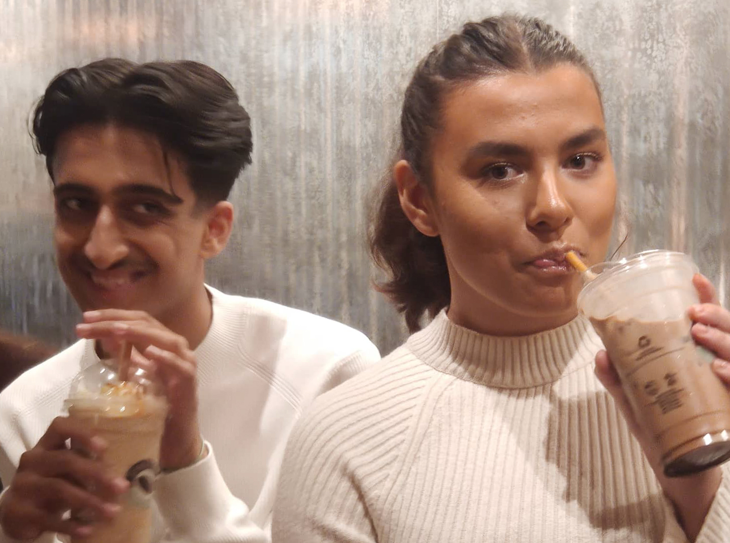 Nærbilde av gutt og jente med hver sin milkshake