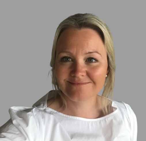 Bilde av kvinne fra skuldre og opp mot grå bakgrunn. Hun har hvit t-skjorte og lyst hår.