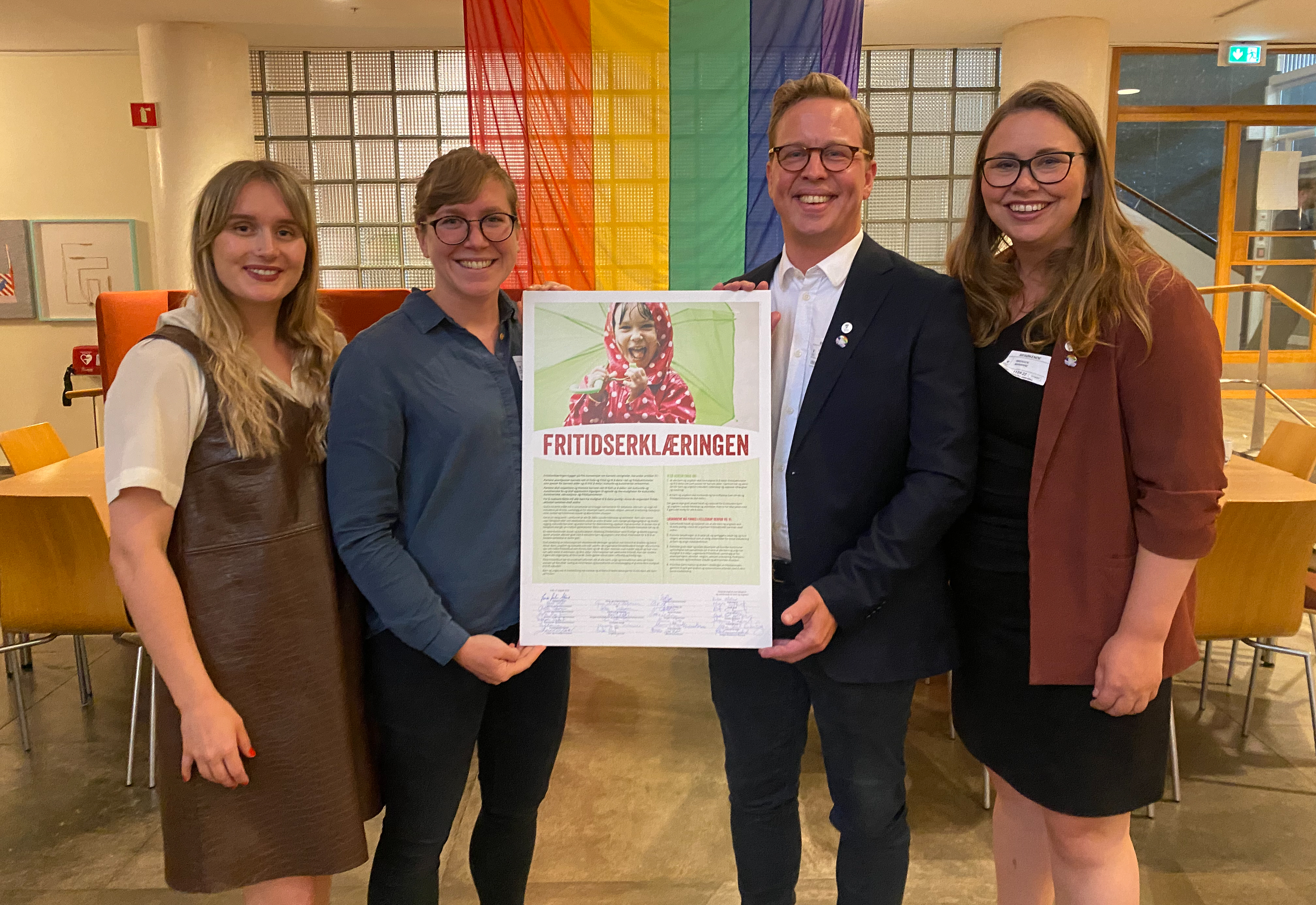 Gruppefoto med 4 perosoner som holder Fritidserklæringen i mellom seg på midten