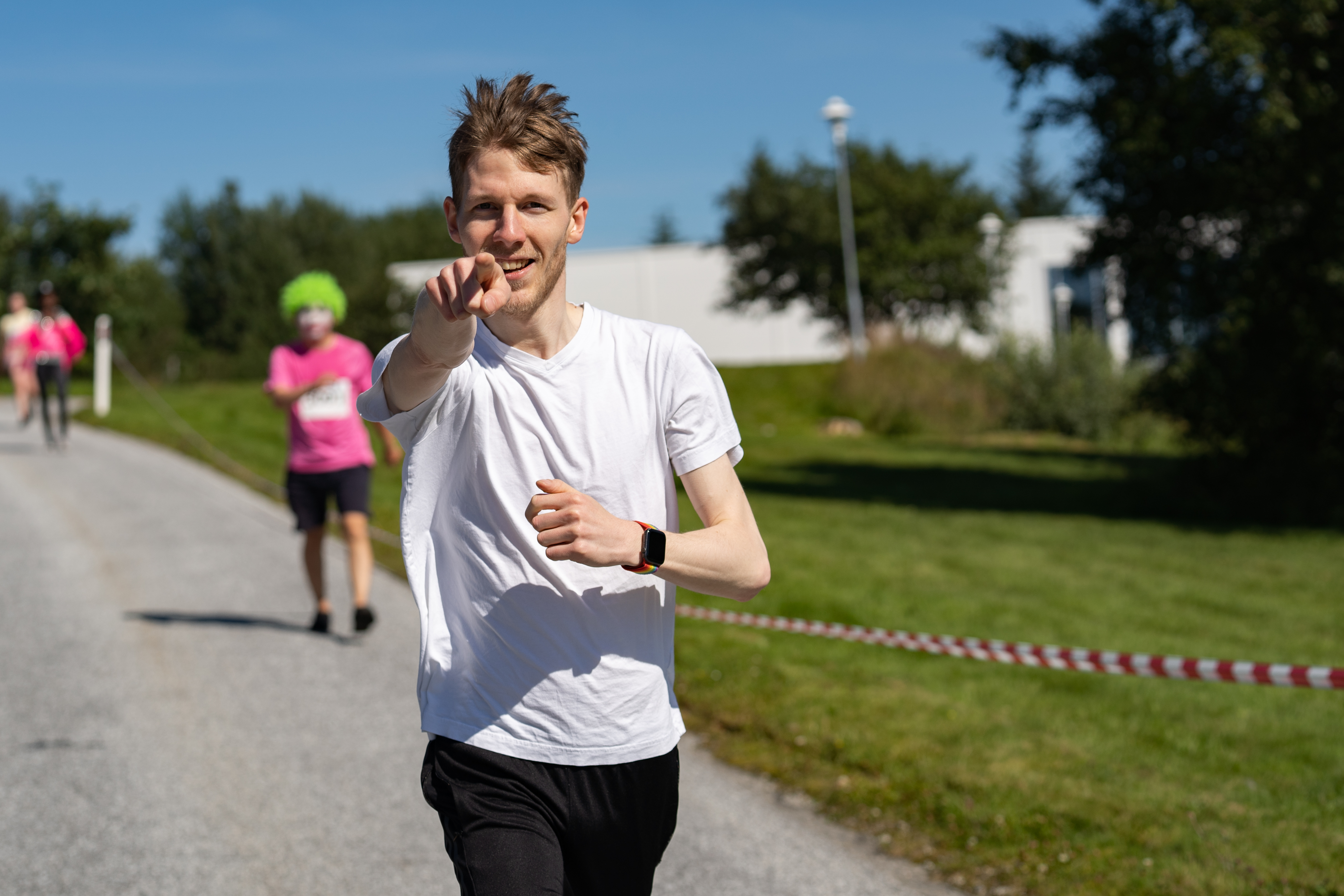 Mannsperson peker i kameraet mens han løper.